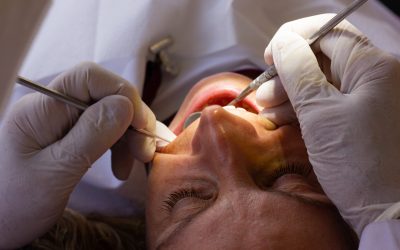 dentist-with-latex-gloves-using-orthodontic-instruments-checking-teeth-female-patient