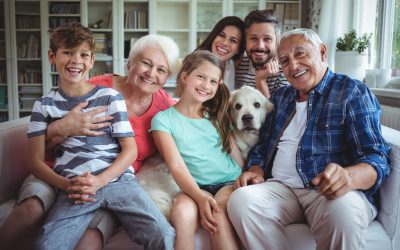 Portrait of happy multi-generation family sitting on sofa in living room at home